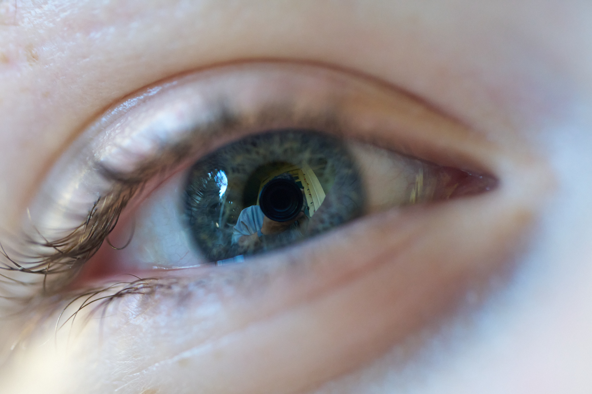 A cmacro shot of a human eye with the photographer visible in it.