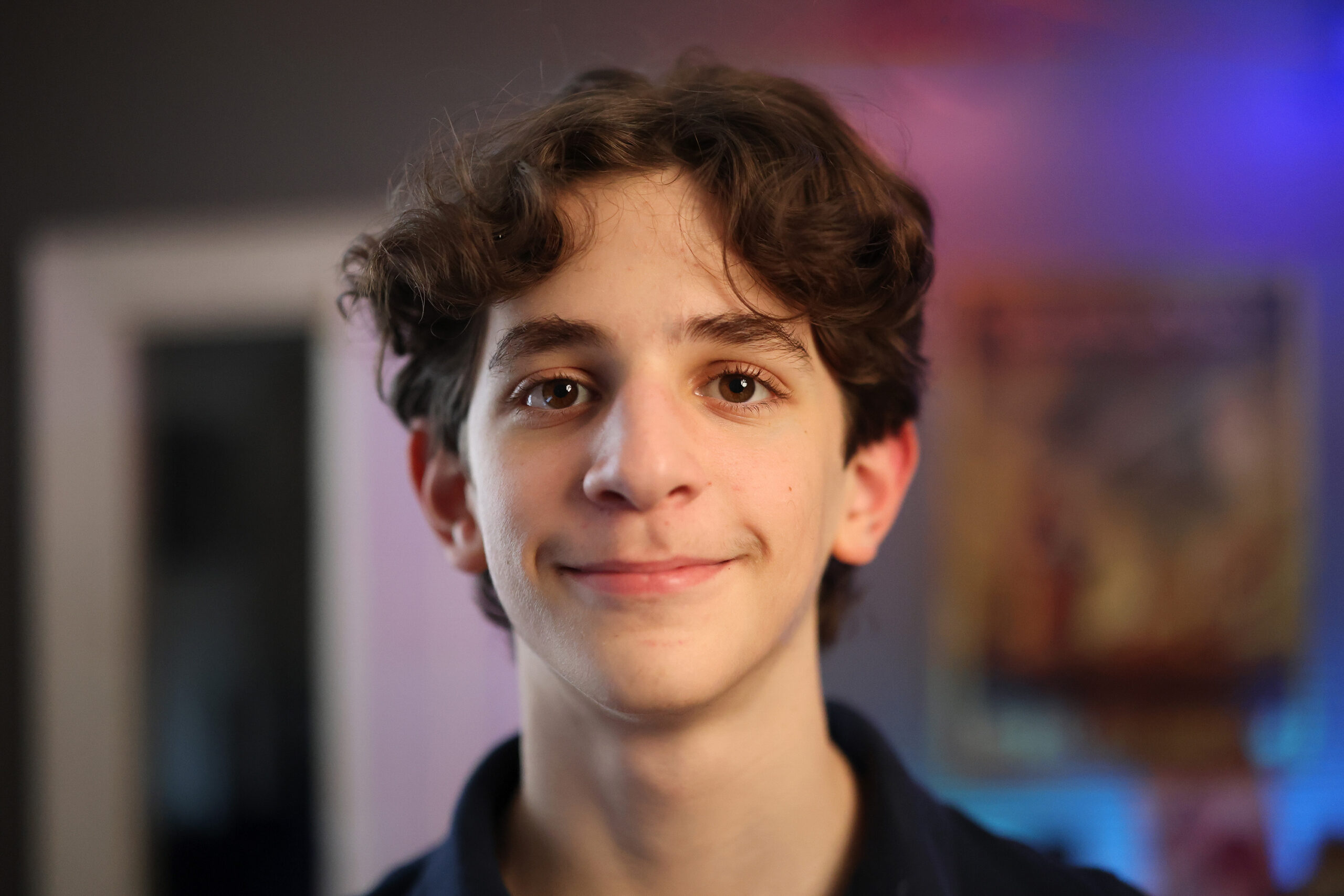 A portrait of a teenager in a colorful room.