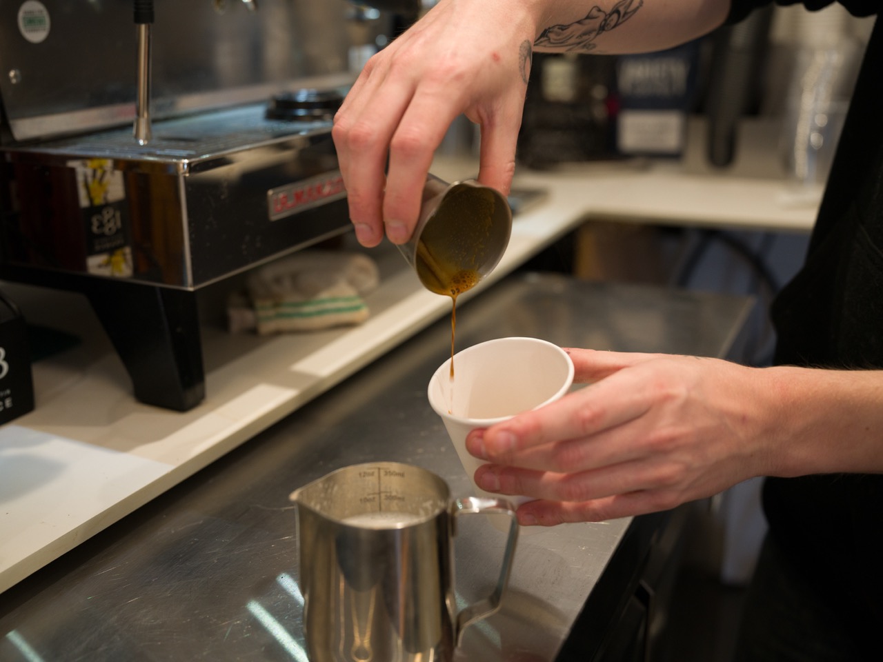 A shot of espresso being poured into a cup