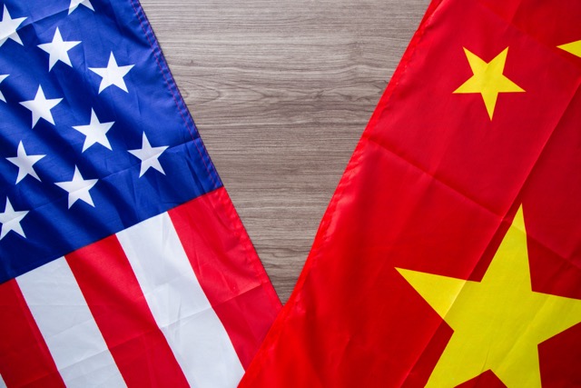 The flags of the United States and China, overlapped on a table.