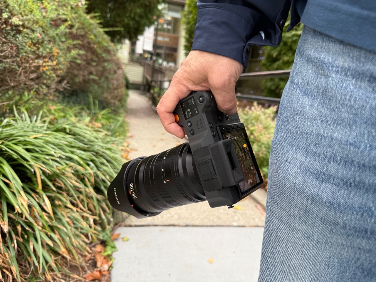Holding an X1D II 100C with the lcd screen showing the image