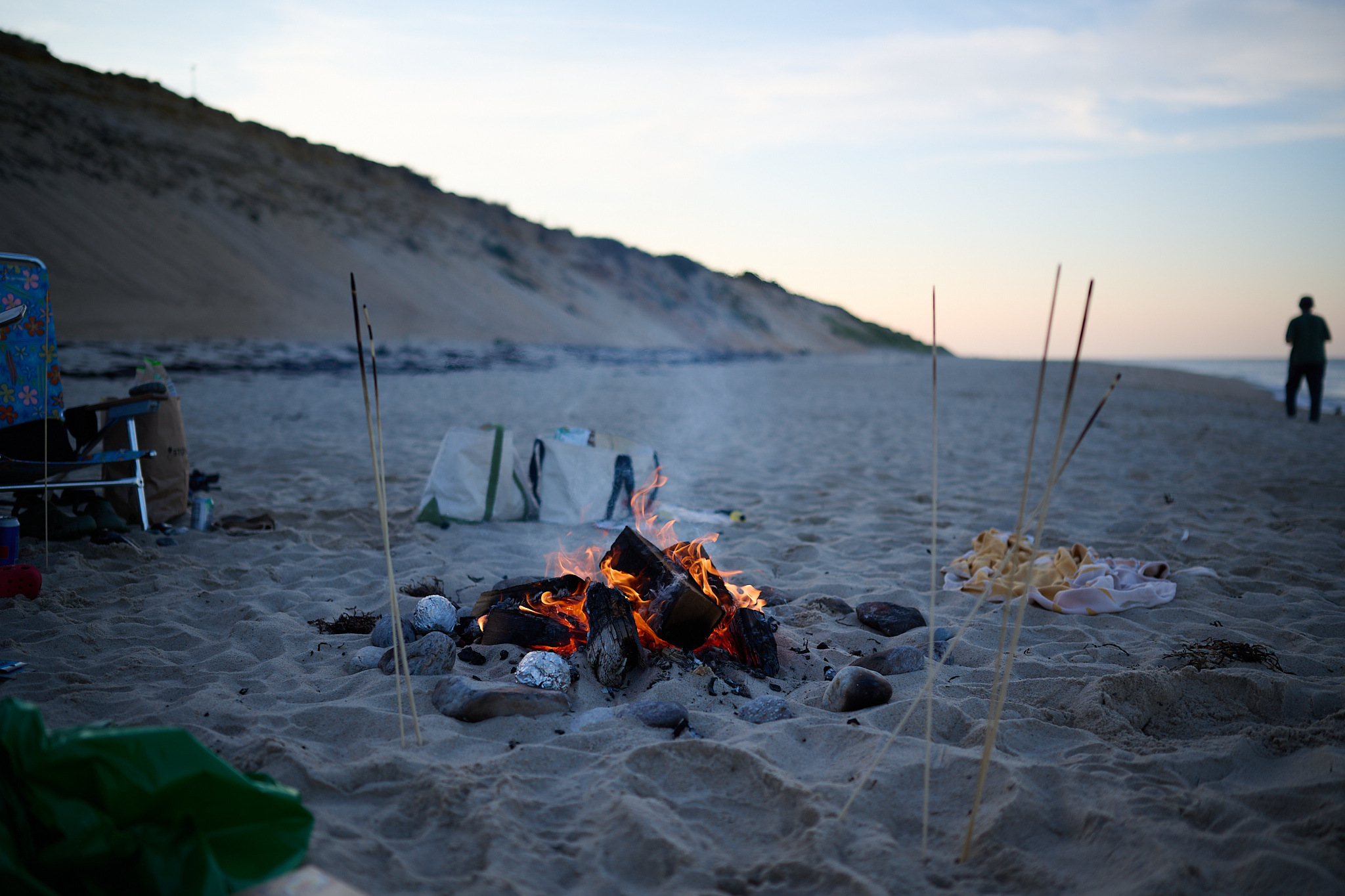 A campfire at night on a beach.