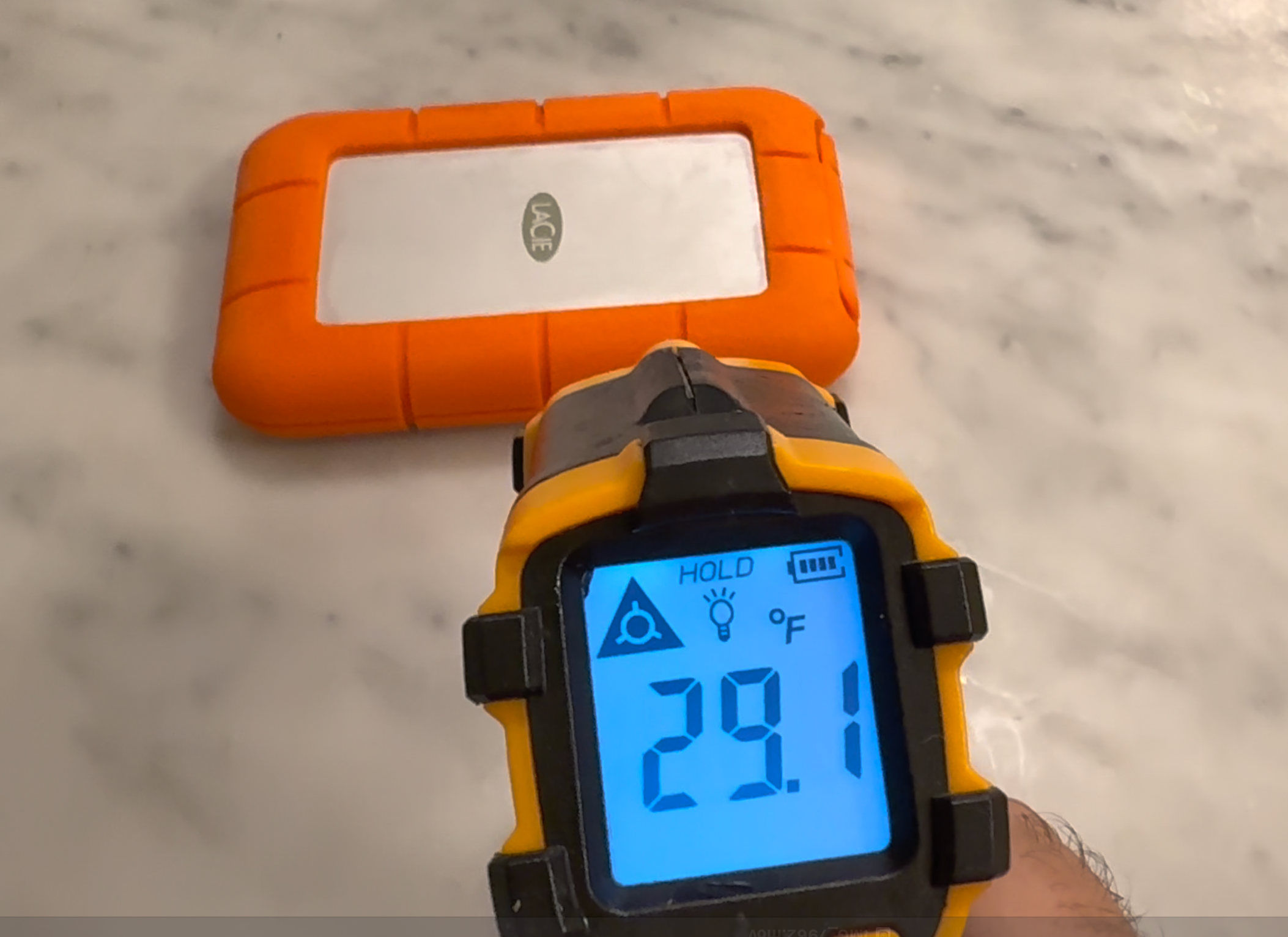 A digital thermometer measuging the temperature of the LaCie Rugged SSD