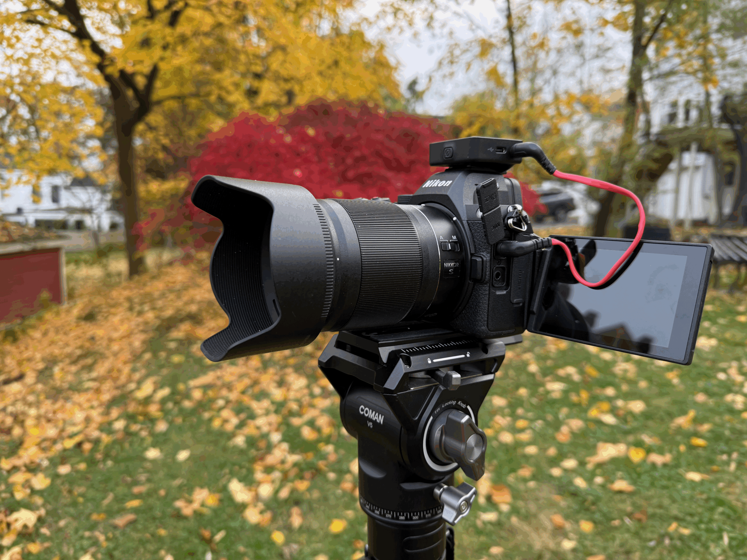 A product shot of the Nikon Z5 II camera.on a tripod outdoors in fall.